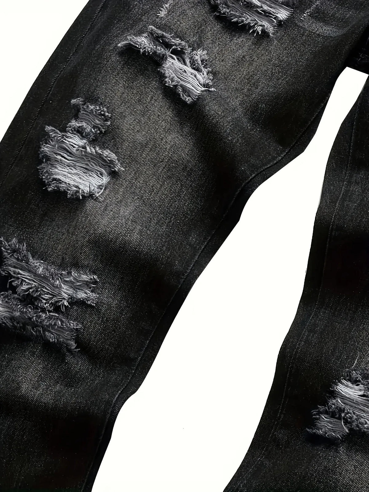Close-up of the inner leg seam and multiple distressed rip patches on dark grey denim