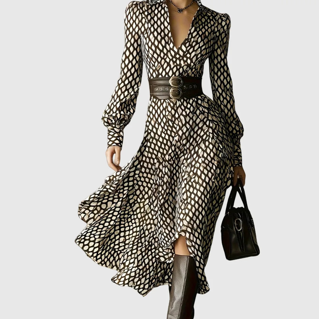 Woman wearing a brown and cream diamond-print midi dress with wide belted waist, carrying a black leather handbag