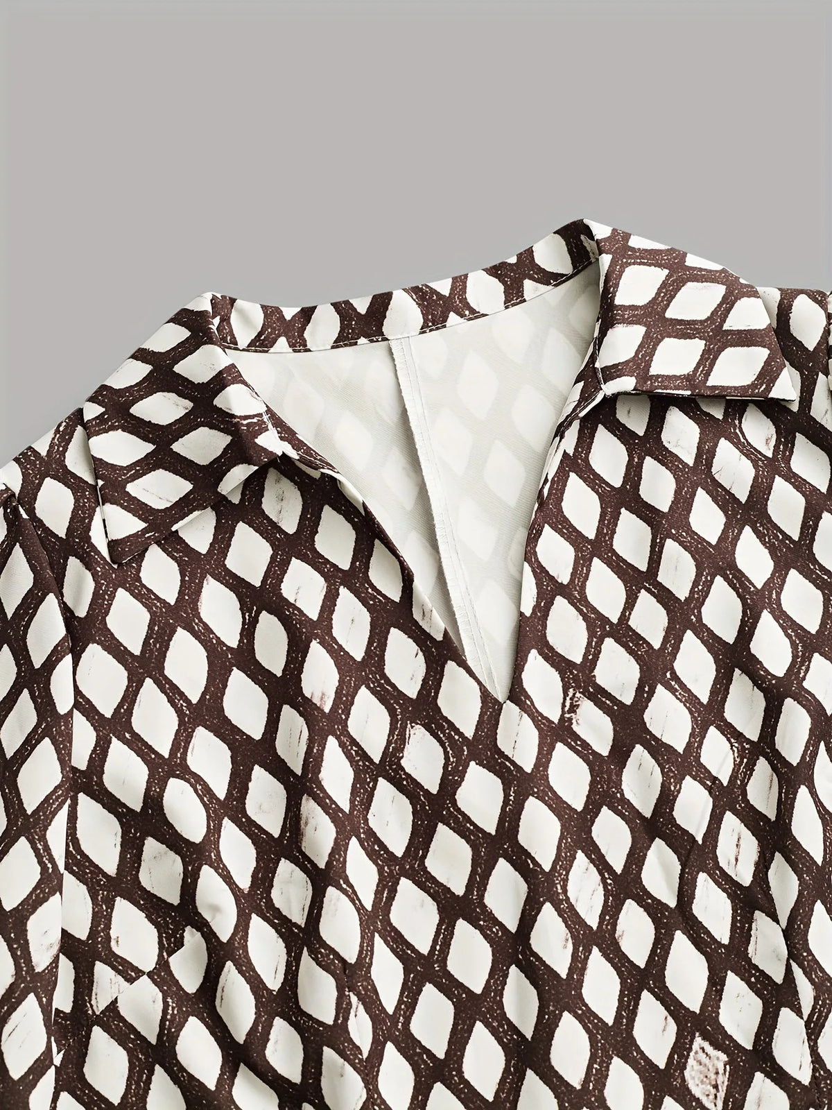 Close-up of the collar and V-neckline detail showing the sheer trim and the diamond lattice print