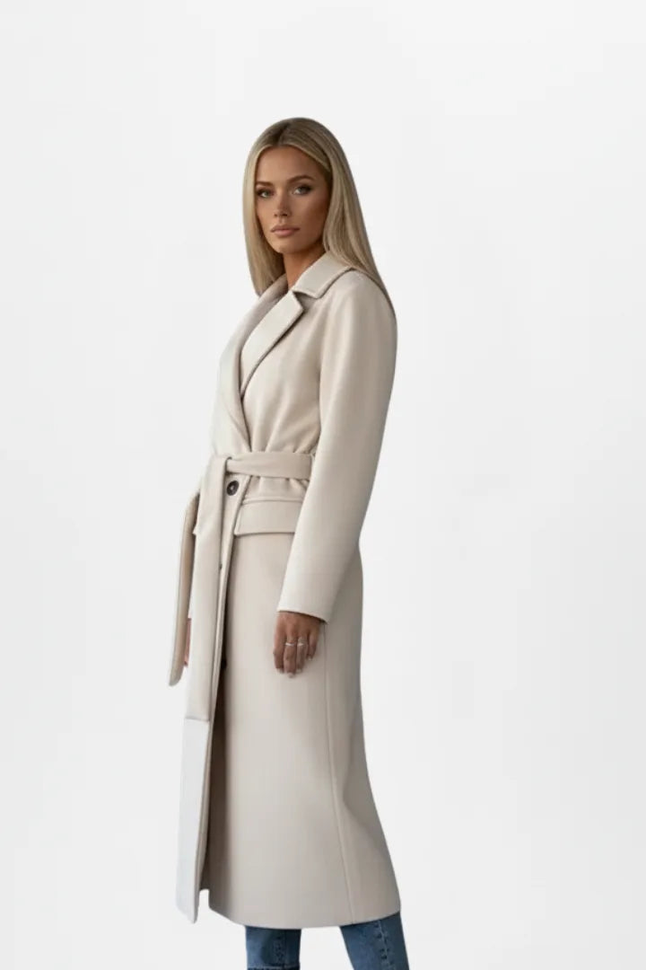 Close side profile of a beige belted coat showing the notch lapel and structured shoulder