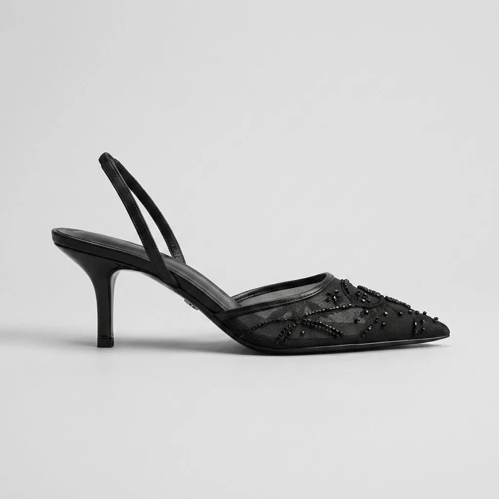 Studio side profile of a black mesh pointed toe kitten heel with beaded floral embroidery and slingback strap