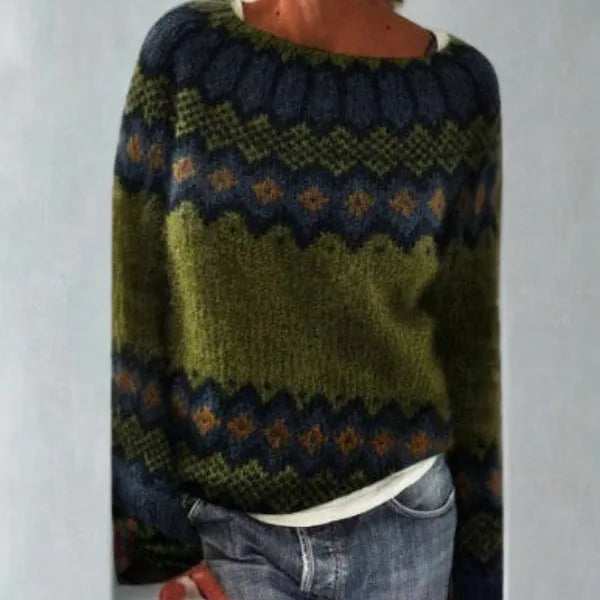 Close view of a green Fair Isle jumper with navy, mustard and rust patterned yoke and cuffs, worn with jeans