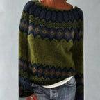 Close view of a green Fair Isle jumper with navy, mustard and rust patterned yoke and cuffs, worn with jeans