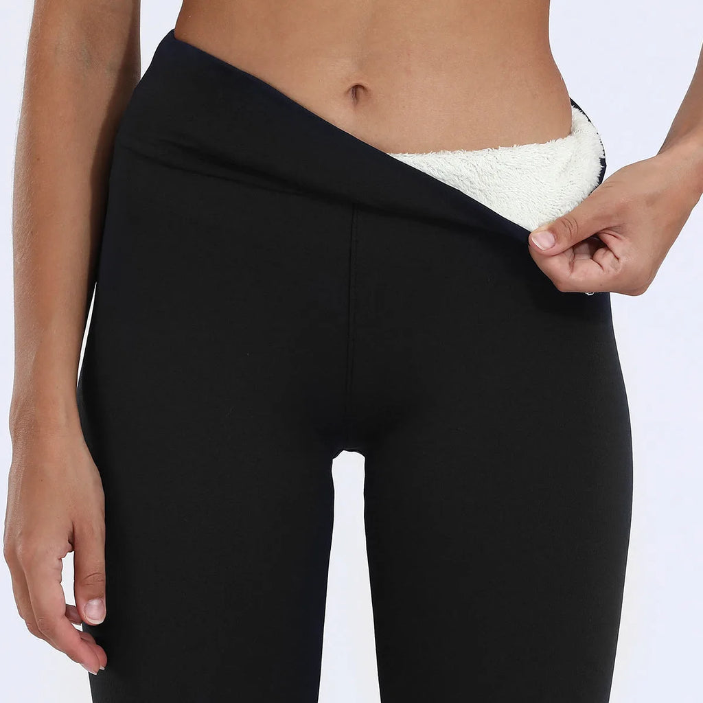 Side view of the black waistband folded down to reveal the plush cream fleece lining underneath