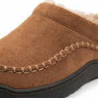 Close-up of the stitched moccasin-style seam and suede texture on a tan clog slipper