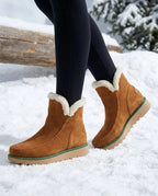 Tan suede ankle boots with cream shearling collar and green-trimmed platform sole, worn while walking in snow
