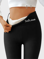Close-up back view of black thermal leggings pulled open at waistband to show soft white fleece lining