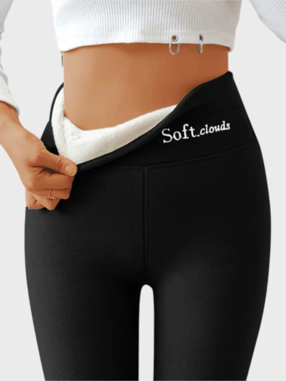 Close-up back view of black thermal leggings pulled open at waistband to show soft white fleece lining