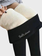 Model holding waistband away from hip showing thick cream fleece inner lining against black fabric