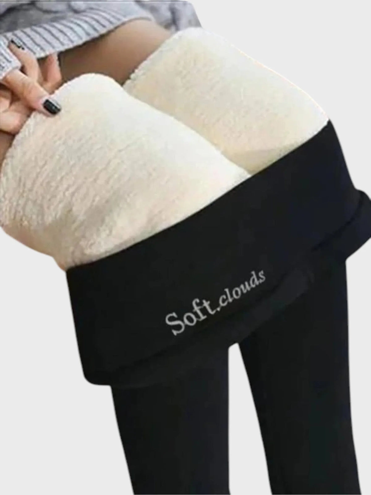 Model holding waistband away from hip showing thick cream fleece inner lining against black fabric