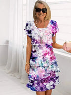 Purple and pink galaxy floral print tiered midi dress with flutter sleeves, round neckline detail