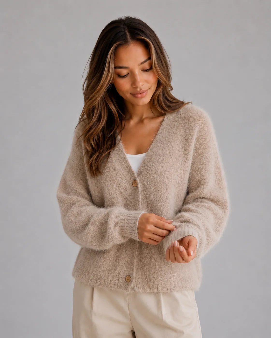 Close-up front view of the beige fluffy cardigan showing the button fastening and soft brushed knit texture