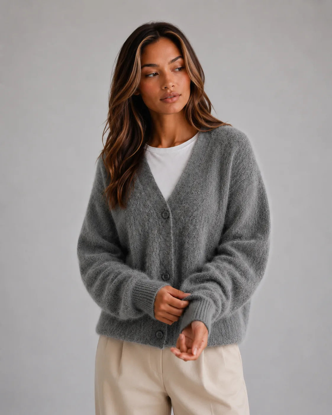 Woman wearing the fluffy cardigan in dark grey with ribbed cuffs and V-neck over a white top