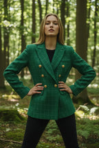 Front view of a woman posing with hands on hips, showcasing the tailored fit and double-breasted button detail of the green tweed blazer.