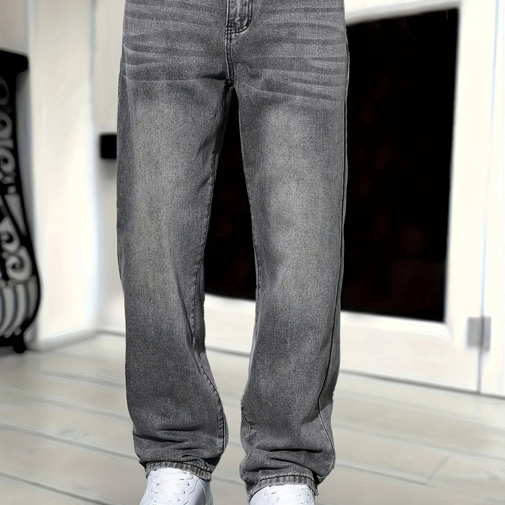 Close-up front view of grey denim jeans showing fly, waistband stitching and fabric wash detail