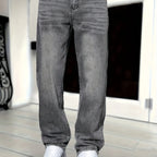 Close-up front view of grey denim jeans showing fly, waistband stitching and fabric wash detail