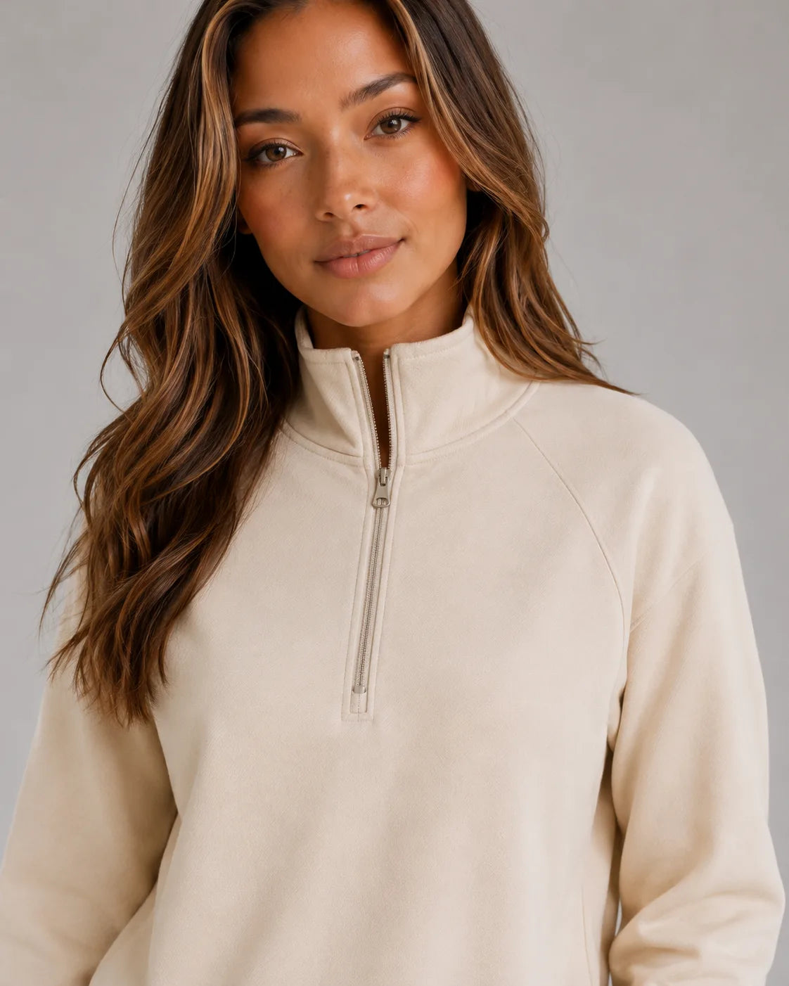 Close up of the cream half zip jumper showing the stand collar, zip pull and soft brushed fabric texture