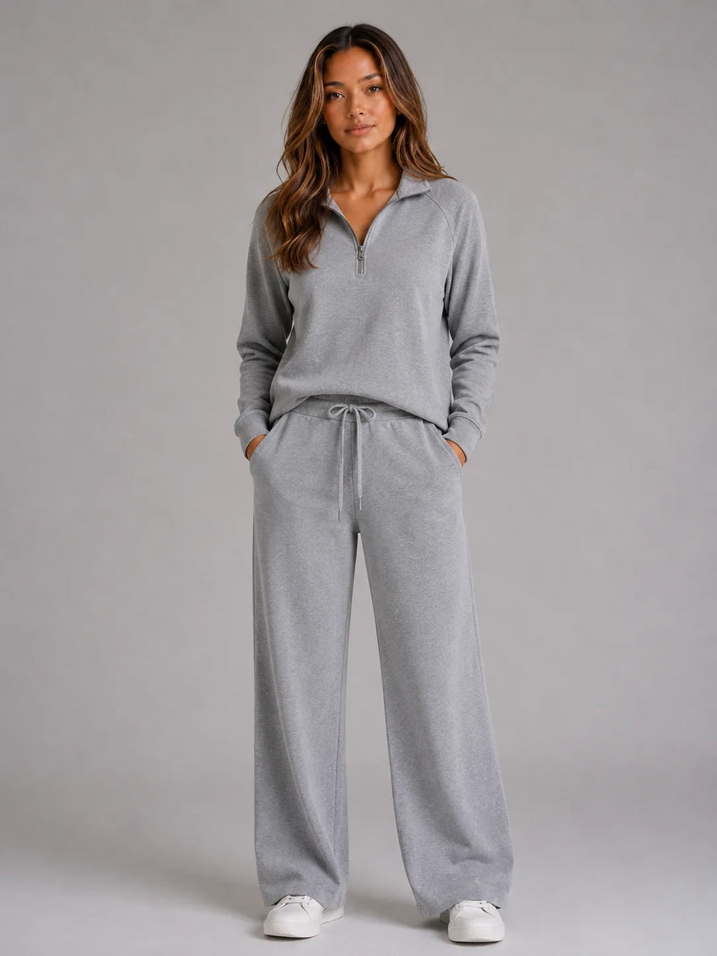 Front view of the loungewear set in light grey marl, worn with a half zip jumper and wide leg trousers