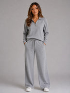 Front view of the loungewear set in light grey marl, worn with a half zip jumper and wide leg trousers