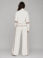 Back view of cream half zip sweatshirt and wide leg trousers showing brown stripe detailing down the leg