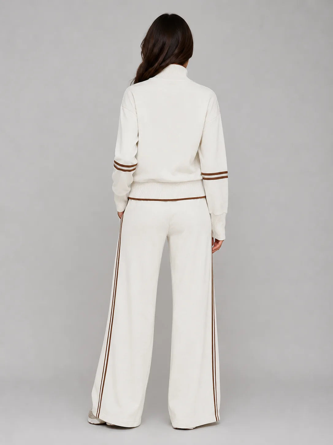 Back view of cream half zip sweatshirt and wide leg trousers showing brown stripe detailing down the leg