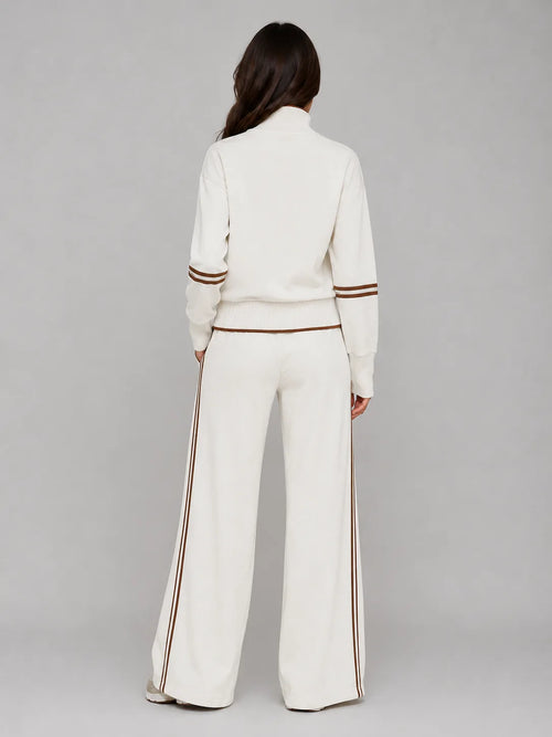 Back view of cream half zip sweatshirt and wide leg trousers showing brown stripe detailing down the leg