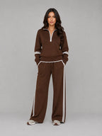 Front view of brown half zip lounge sweatshirt and wide leg trousers with white stripe trim