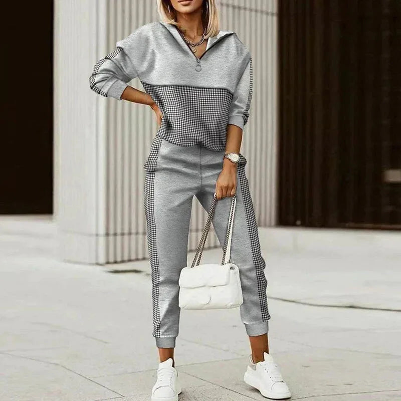 Grey half-zip tracksuit with black and white checked panel across the chest and matching side stripe on the joggers