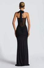 Back view of the black gown showing the tied halter strap and ruched fabric cascading down the skirt