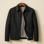 Black harrington jacket on wooden hanger, open front showing black and white checked lining and zip