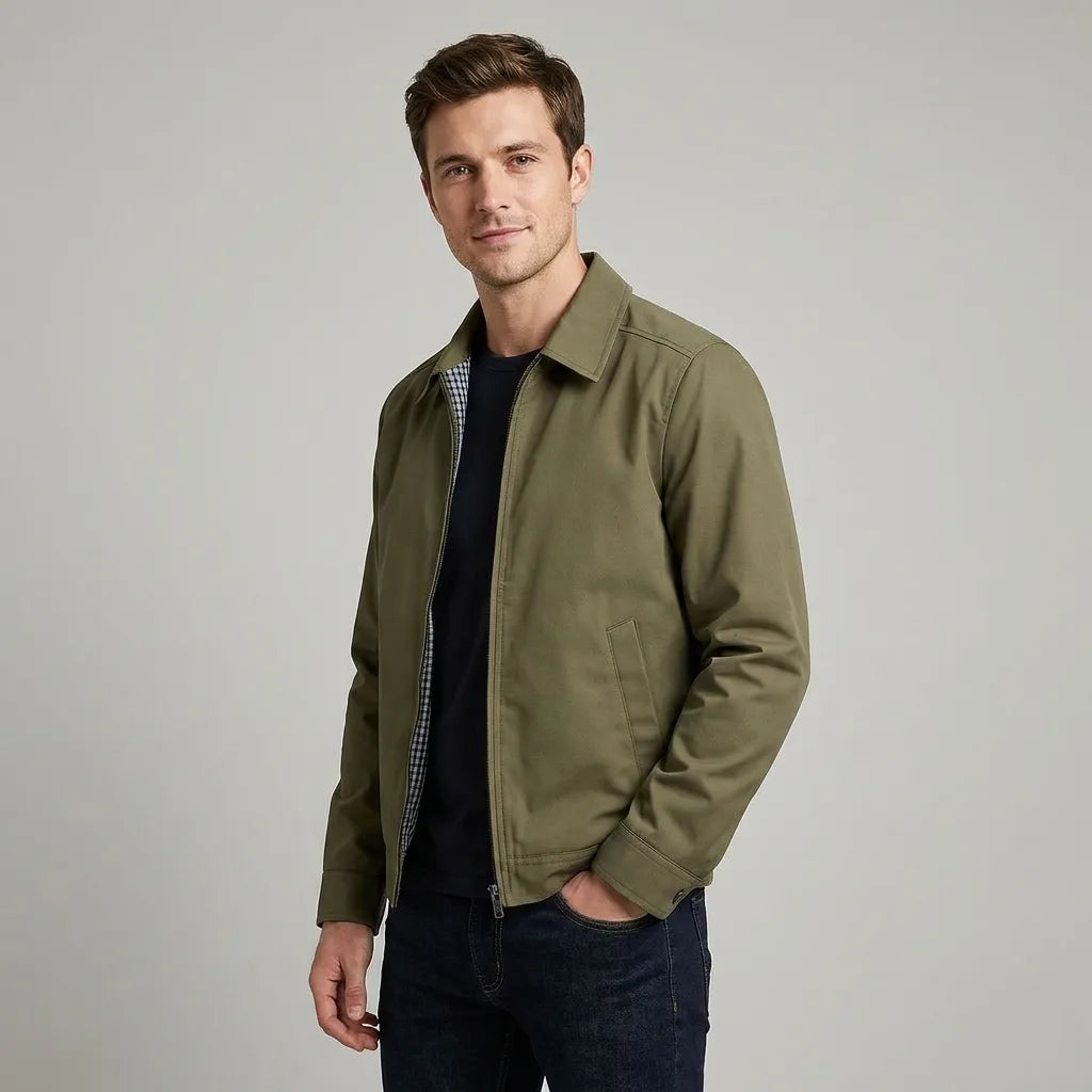 Man wearing olive green harrington jacket open over a dark t-shirt, three-quarter view