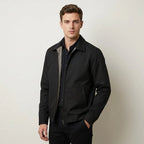 Close-up of black harrington jacket zip pull and welt pocket detail