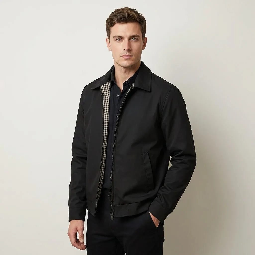 Close-up of black harrington jacket zip pull and welt pocket detail