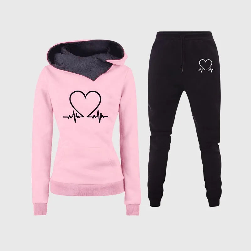 Pink hooded sweatshirt with grey lined hood and heartbeat heart graphic, paired with matching black joggers