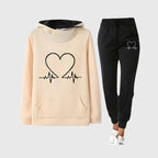 Cream hoodie with black heart pulse graphic and contrast hood, paired with black joggers featuring a small heart print