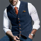 Man in white shirt and orange tie wearing a navy herringbone waistcoat with wooden buttons, front view