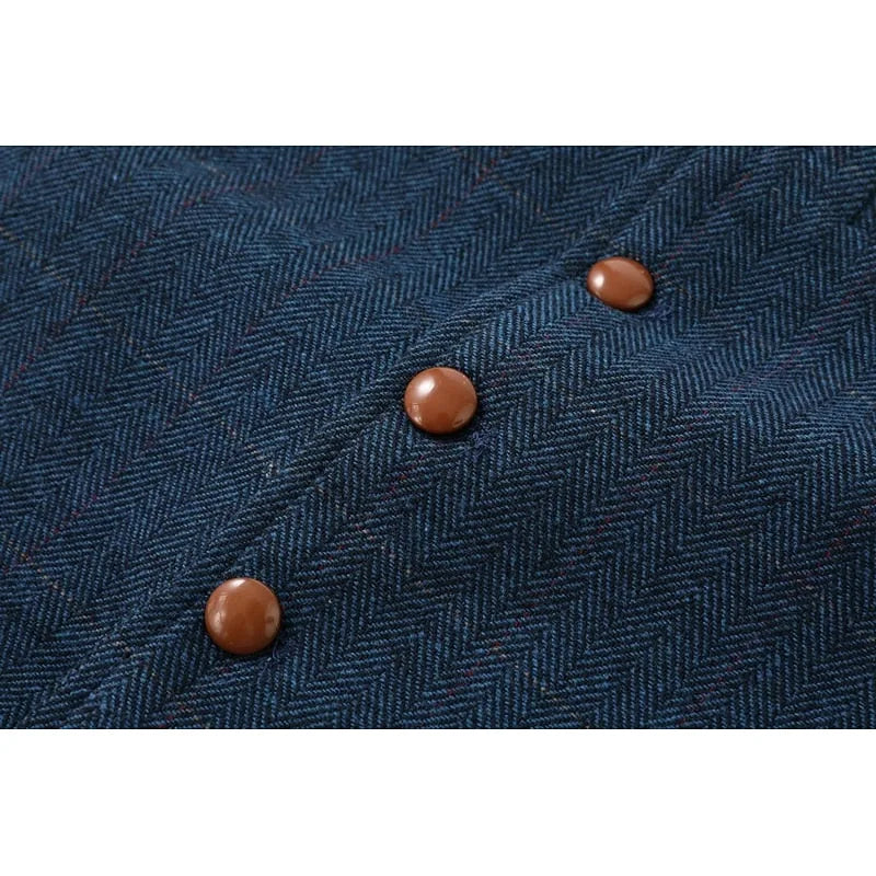 Macro shot of the herringbone weave fabric with brown button fastenings on the waistcoat