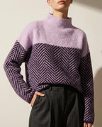 Close-up of a lavender mock neck jumper with a navy and cream herringbone knit panel across the chest and sleeves