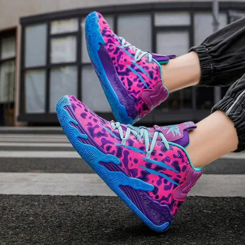 On-foot shot of pink, purple and blue leopard-print high-top basketball shoes with blue swirl sole, worn with cropped trousers