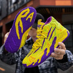 Close-up of bright yellow and purple high-top basketball shoe held up to show the textured purple swirl outsole