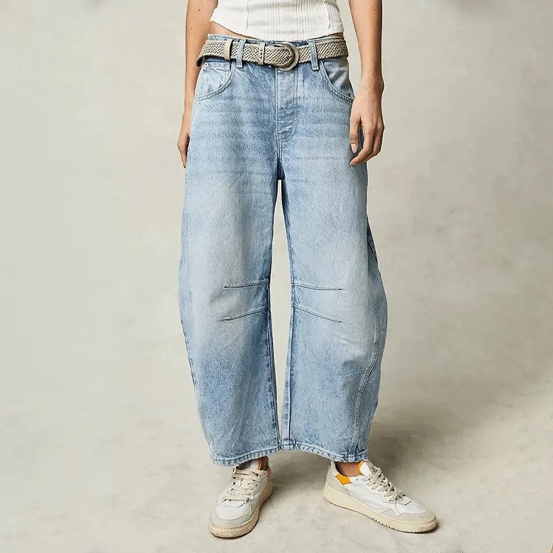 Faded light-wash barrel jeans styled with a woven belt and white trainers