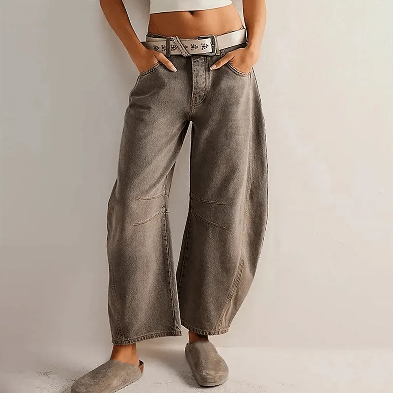Grey-brown washed barrel jeans worn with a metallic belt and grey fuzzy mule slides