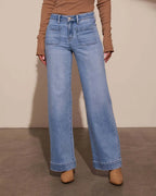 Light blue wide-leg jeans with front patch pockets, paired with suede ankle boots and a camel jumper