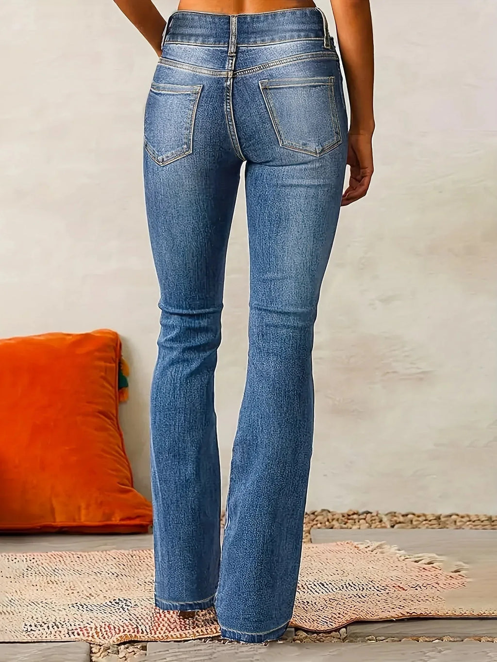 Rear view of blue flared jeans showing classic five-pocket styling and contoured waistband stitching