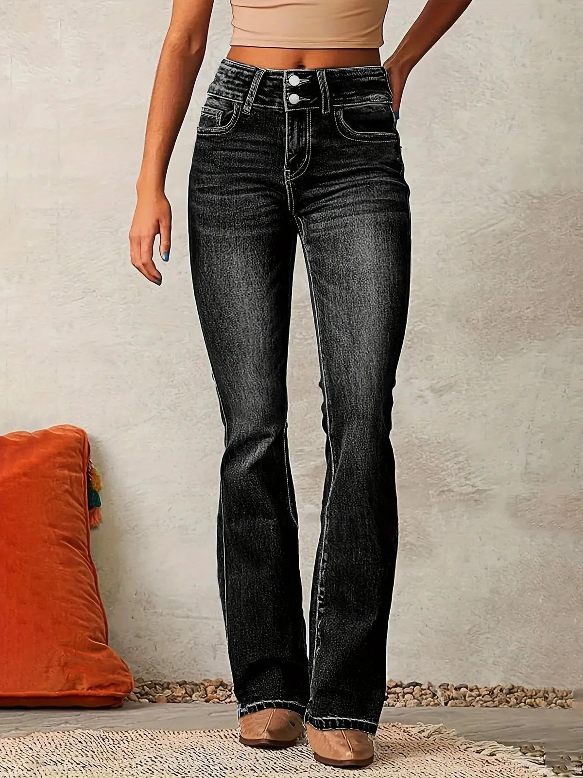 Front view of high-waisted flared jeans in a dark, faded black wash with double-button closure