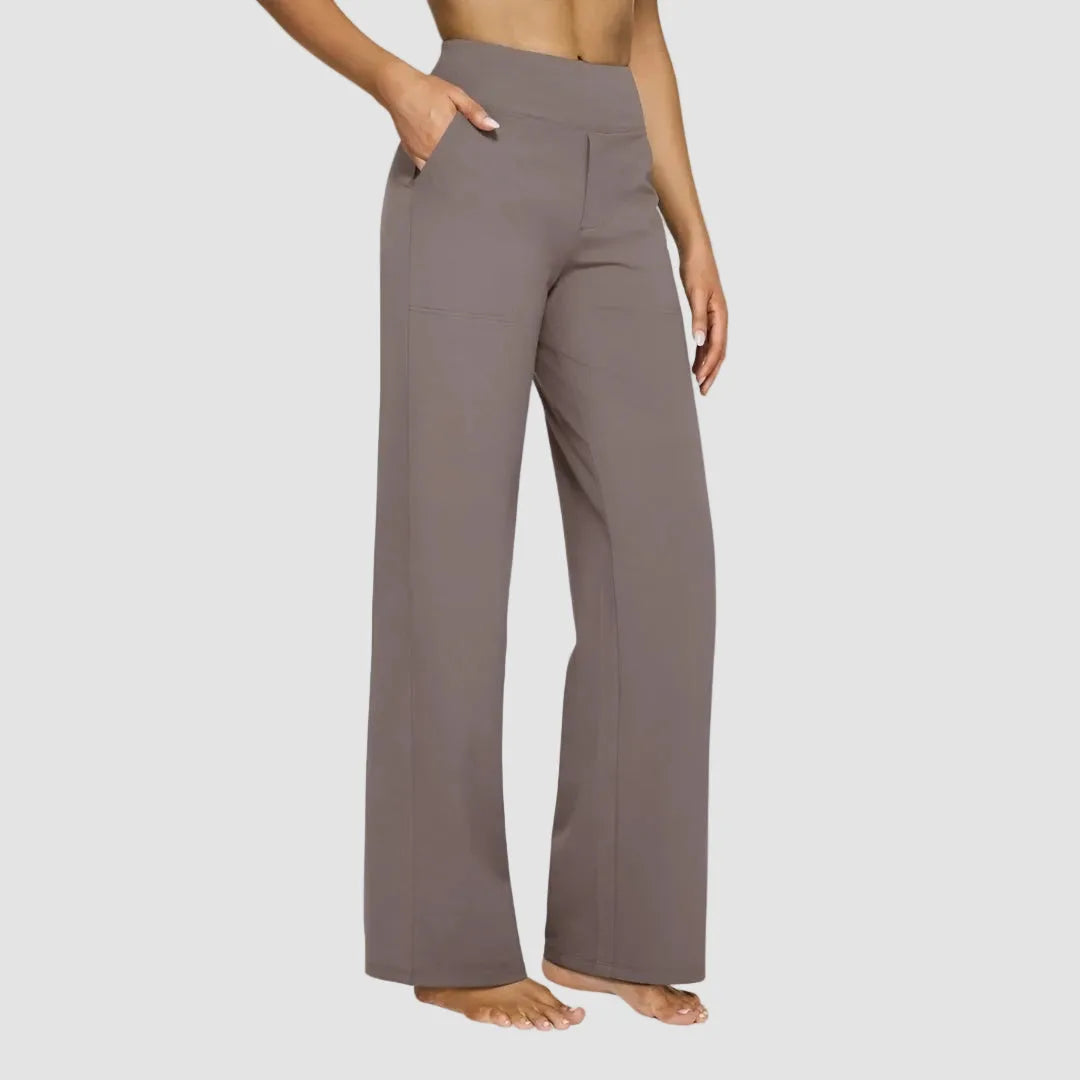 Side view of taupe high-waisted wide-leg trousers with hand tucked into the front pocket