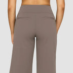 Back view of the taupe trousers highlighting the fitted waistband and twin faux welt pockets