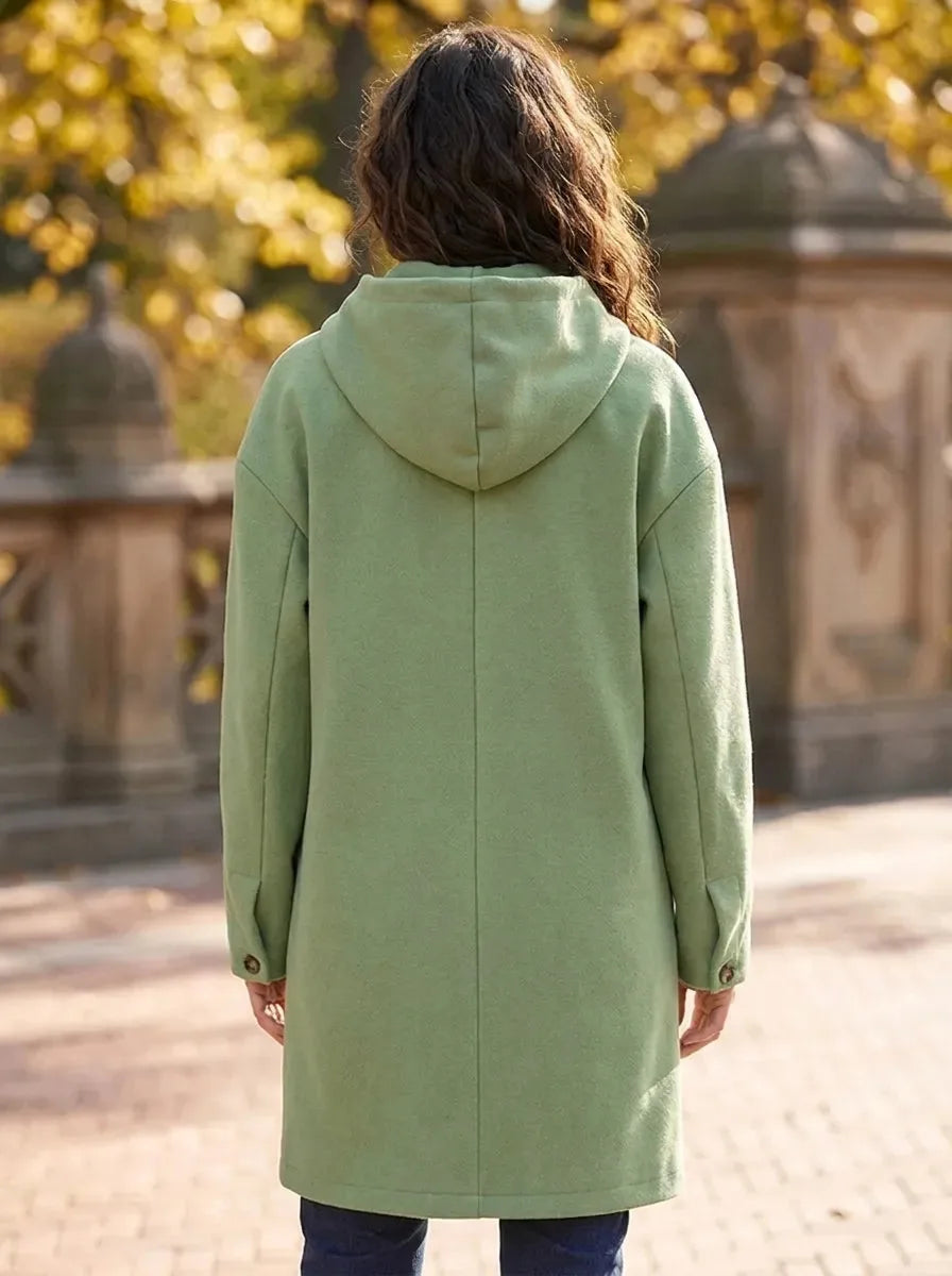 Back view of the sage green hooded longline coat showing the seam detailing and cuff button