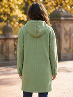 Back view of the sage green hooded longline coat showing the seam detailing and cuff button