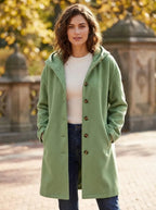 Sage green hooded coat worn open over a cream ribbed jumper, styled with jeans